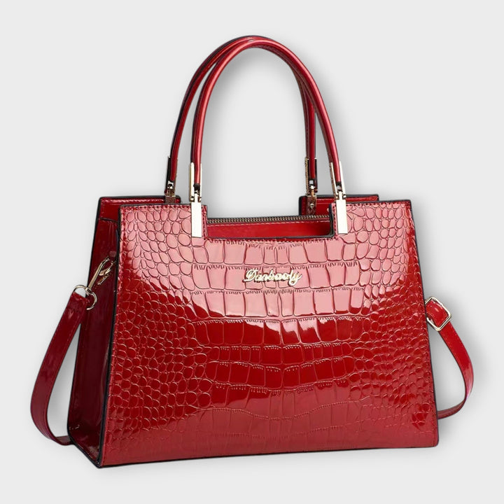 Cécile. - Bolsa de mão em padrão de pele de crocodilo brilhante