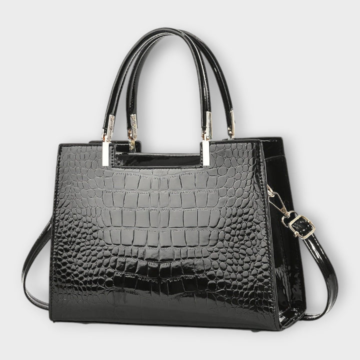 Cécile. - Bolsa de mão em padrão de pele de crocodilo brilhante